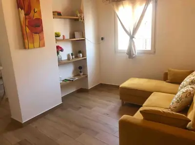 a living room with a couch and a window at Appartamento NA ME CASA in Palermo