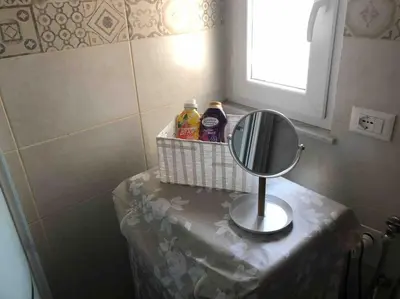 a bathroom with a mirror and some bottles of cleaner at Appartamento NA ME CASA in Palermo