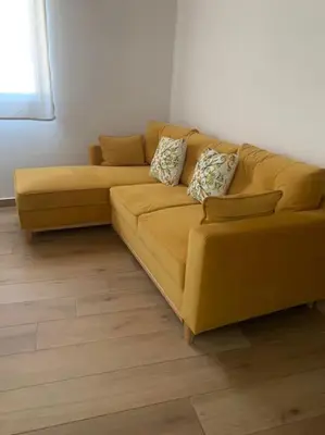 a yellow couch sitting in a living room at Appartamento NA ME CASA in Palermo