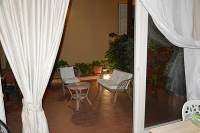 a patio with chairs and a table and a curtain at La casetta nel verde in Palermo