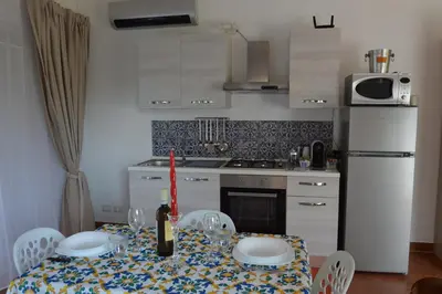 a kitchen with a table with a bottle of wine at La casetta nel verde in Palermo