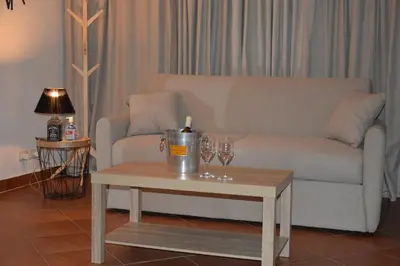 a living room with a couch and a table with wine glasses at La casetta nel verde in Palermo