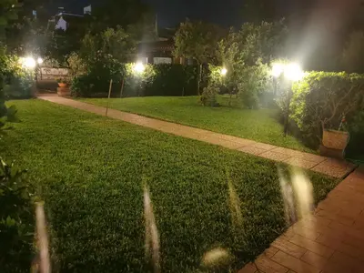 a walkway in a yard at night with lights at La casetta nel verde in Palermo