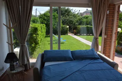 a bed in a room with a large window at La casetta nel verde in Palermo