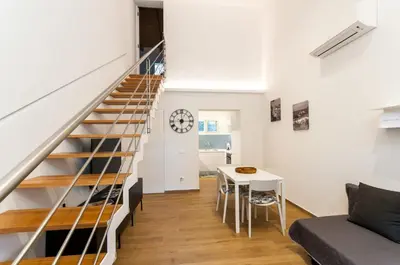 a staircase in a living room with a table at White Home in Castellammare del Golfo