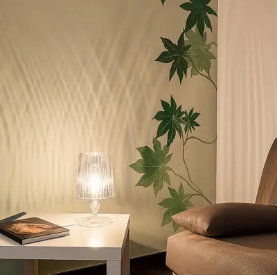 a table with a lamp and a plant on the wall at La Residenza dell' Alloro in Palermo