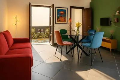 a living room with a red couch and a table and chairs at La Residenza dell' Alloro in Palermo
