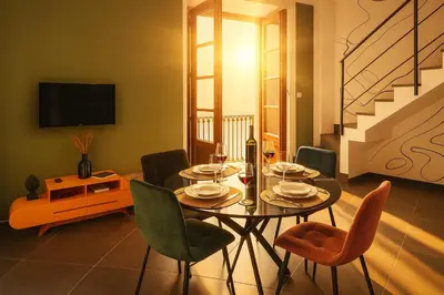 a dining room with a table with chairs and a tv at La Residenza dell' Alloro in Palermo