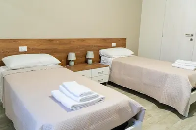 two beds in a room with white towels on them at Gennaro Holidays in Corleone