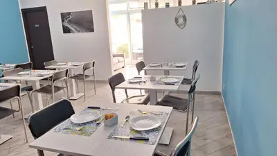 a restaurant with tables and chairs with plates on them at B&B A Mare in Castellammare del Golfo