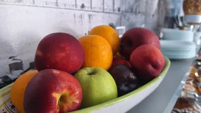 a bowl of fruit on a counter with oranges and apples at B&B A Mare in Castellammare del Golfo