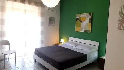 a bedroom with a bed and a green wall at B&B A Mare in Castellammare del Golfo