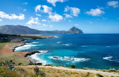 a view of the ocean with mountains in the background at Makari Bay Home in San Vito lo Capo