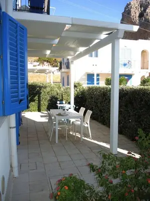 a patio with a table and chairs under a white pergola at Makari Bay Home in San Vito lo Capo