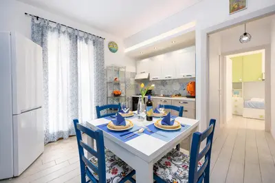 a kitchen and dining room with a white table and chairs at Appartamento Dolceluna in San Vito lo Capo