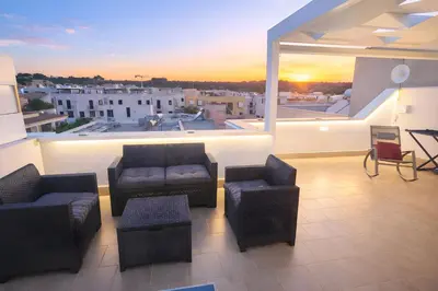 a living room with couches and chairs on a balcony at Appartamento Dolceluna in San Vito lo Capo