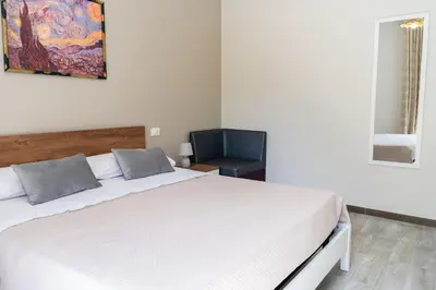 a bedroom with a white bed and a chair at Gennaro Holidays Appartament in Corleone