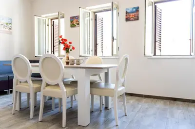 a dining room with a white table and chairs at Gennaro Holidays Appartament in Corleone