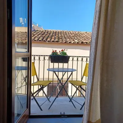a table and chairs on a balcony with a window at Genius Home in Palermo