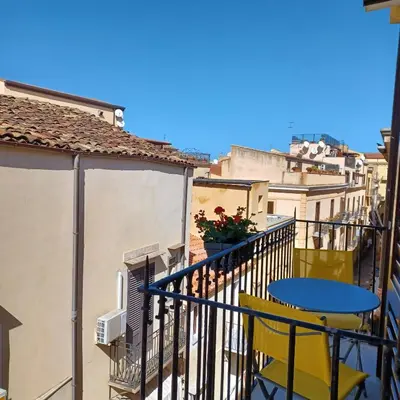 a balcony with a blue table and yellow chairs at Genius Home in Palermo