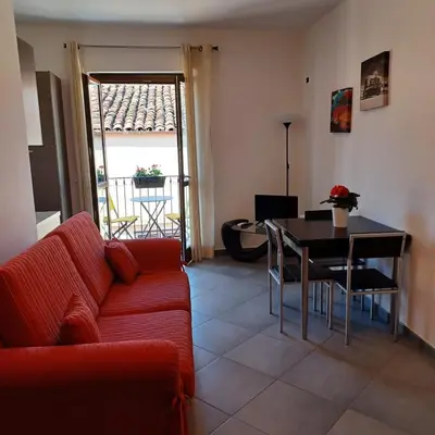 a living room with a red couch and a table at Genius Home in Palermo