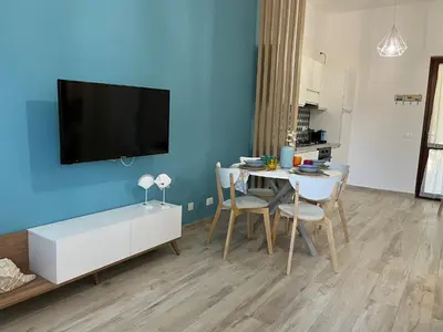a living room with a table and a tv on a blue wall at Ca San Vito Lo Capo Villa Maria in San Vito lo Capo