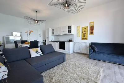 a living room with a blue couch and a kitchen at La Villa di Nonna Pina in Balestrate