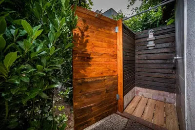 an outdoor shower with a wooden door at La Casetta in San Vito lo Capo
