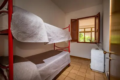 a bedroom with two bunk beds and a window at La Casetta in San Vito lo Capo