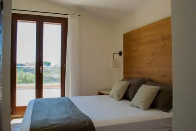 a bedroom with a large bed with a large window at Feudo Del Biviere in Santa Ninfa