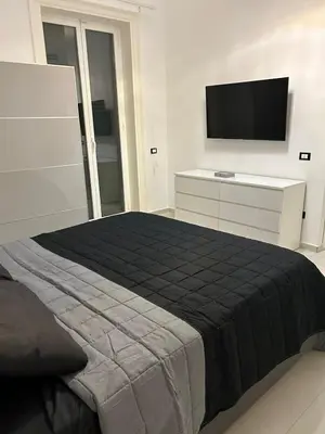 a bedroom with a bed with a television on the wall at MARGOT HOUSE PALERMO in Palermo