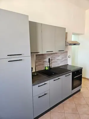 a kitchen with white cabinets and a black counter top at Simone Cupolas View in Palermo