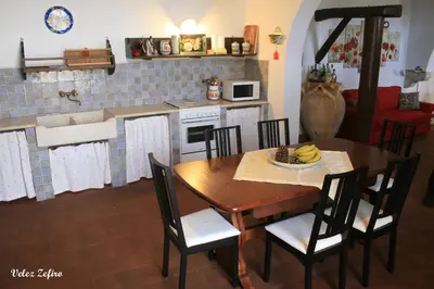 a kitchen and dining room with a table and chairs at Baglio 