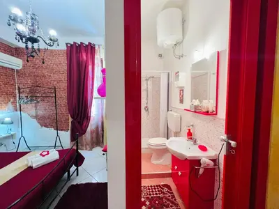 a red bathroom with a toilet and a sink at Regina Elena in Cinisi