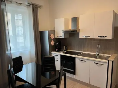 a kitchen with white cabinets and a table with chairs at Via Serradifalco, Zona Via Dante in Palermo