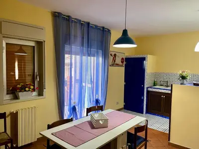 a kitchen with a table and a blue curtain at Sicilian Apartment in Termini Imerese