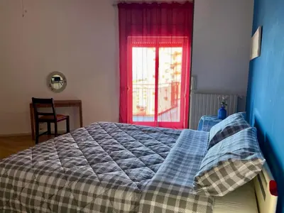 a bedroom with a bed and a red window at Sicilian Apartment in Termini Imerese