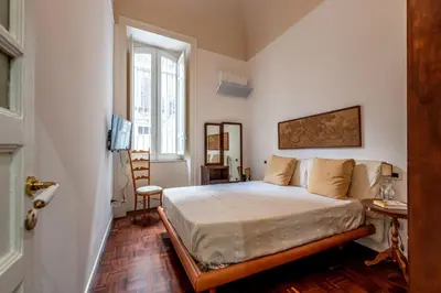 a bedroom with a bed and a large window at Casa Goethe delle Volte by Wonderful Italy in Palermo