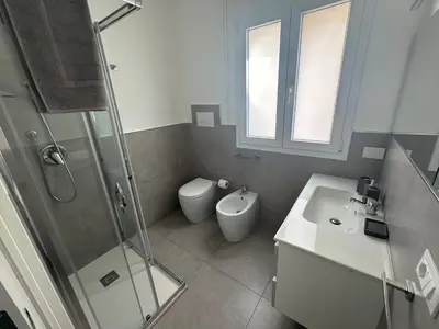 a bathroom with a toilet and a sink and a shower at Villa Oasi Verde in Cinisi