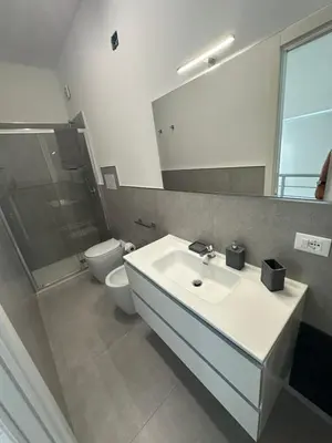 a bathroom with a sink and a toilet and a mirror at Villa Oasi Verde in Cinisi