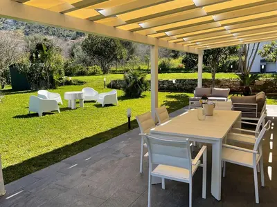 a patio with a table and chairs under a pergola at Villa Oasi Verde in Cinisi