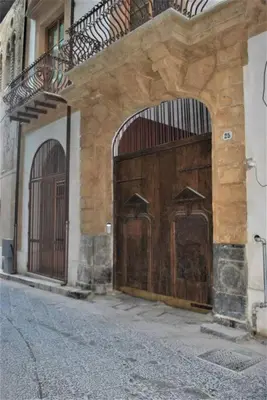 two large wooden doors on the side of a building at TALO' - casa vacanze in Palermo
