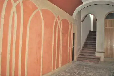 a hallway with a staircase in a building with a door at TALO' - casa vacanze in Palermo