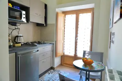 a kitchen with a table with a bowl of fruit on it at TALO' - casa vacanze in Palermo