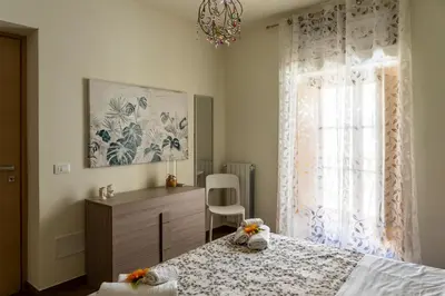 a bedroom with a bed and a dresser and a window at TALO' - casa vacanze in Palermo