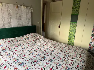 a bedroom with a bed with a floral comforter at Wave house in Palermo