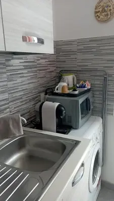 a kitchen counter with a sink and a microwave at Serradifalco Cozy House di Enza e Luigi in Palermo