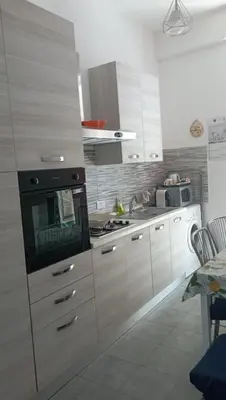 a kitchen with white cabinets and a stove top oven at Serradifalco Cozy House di Enza e Luigi in Palermo