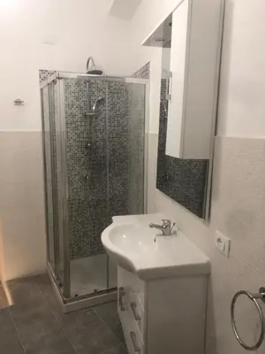 a bathroom with a shower and a sink and a mirror at Serradifalco Cozy House di Enza e Luigi in Palermo