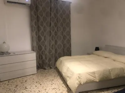 a bedroom with a bed and a dresser in it at Serradifalco Cozy House di Enza e Luigi in Palermo